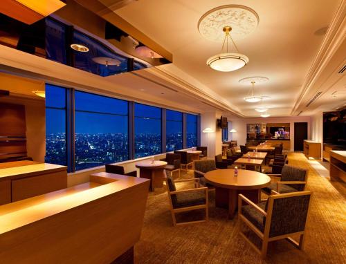 a restaurant with tables and chairs and a view of the city at Hilton Fukuoka Sea Hawk in Fukuoka