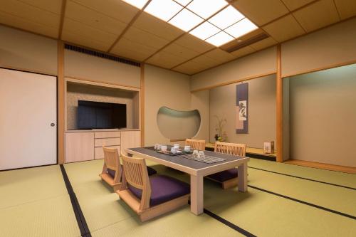 a room with a table and chairs and a television at Hilton Fukuoka Sea Hawk in Fukuoka