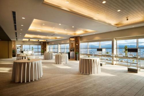 a banquet hall with tables in a room with large windows at Hilton Fukuoka Sea Hawk in Fukuoka