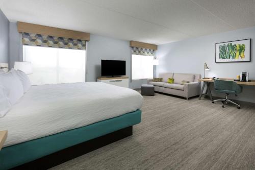 a hotel room with a large bed and a desk at Hilton Garden Inn Greenville in Greenville