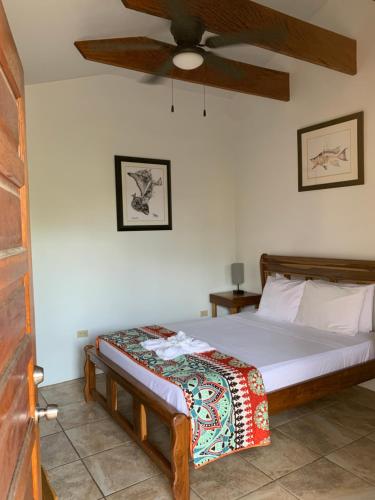 a bedroom with a bed and a ceiling fan at All Seasons Belize in Hopkins