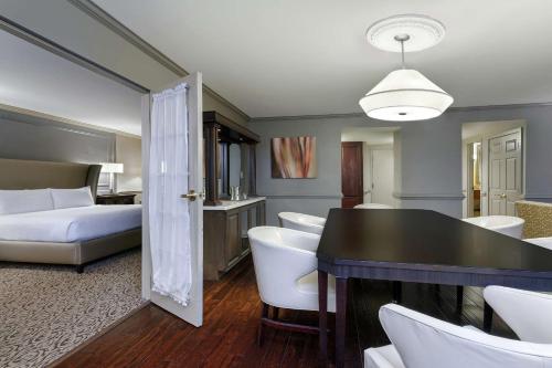 a hotel room with a bed and a table and chairs at Hilton Jackson in Jackson