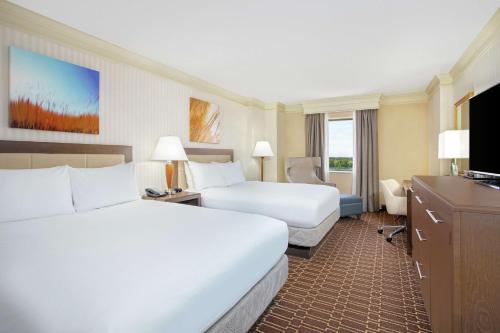 a hotel room with two beds and a television at Hilton Jackson in Jackson