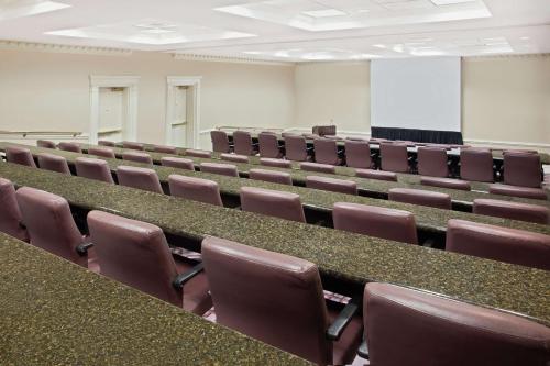 an empty lecture hall with brown chairs and a screen at Hilton Jackson in Jackson