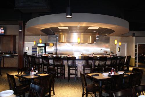 a restaurant with tables and chairs and a bar at Hilton Jackson in Jackson