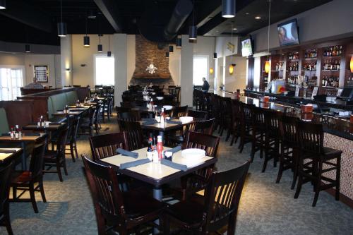 a restaurant with tables and chairs and a bar at Hilton Jackson in Jackson