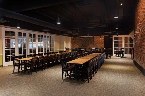 a dining room with tables and chairs and windows at Hilton Jackson in Jackson