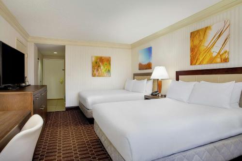a hotel room with two beds and a flat screen tv at Hilton Jackson in Jackson