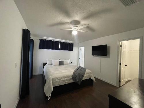 a bedroom with a bed and a ceiling fan at Resort Community 4 Bedroom Family Home, Pool & 15 Min Disney in Kissimmee