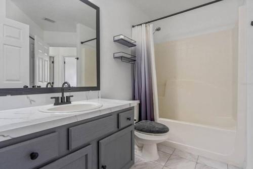 a bathroom with a sink and a toilet and a shower at Resort Community 4 Bedroom Family Home, Pool & 15 Min Disney in Kissimmee