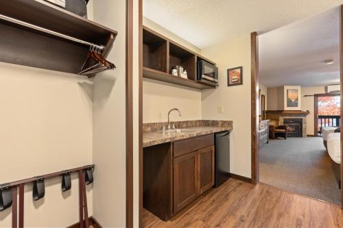 a kitchen with a sink and a living room at Cragun's Resort on Gull Lake in Brainerd