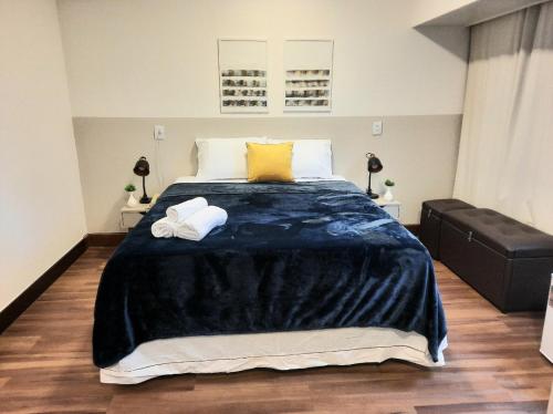 a bedroom with a large bed with two towels at Super Comfort Flats lll - WTC - com Estacionamento in Sao Paulo