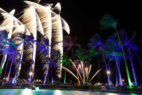 a group of palm trees with fireworks at night at Hilton Waikoloa Village in Waikoloa