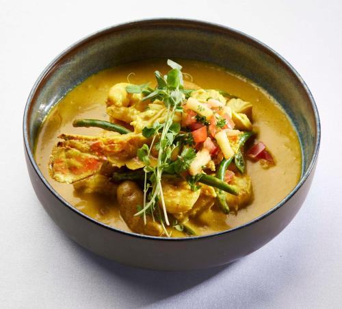 a bowl of soup with chicken and vegetables in it at Hilton Waikoloa Village in Waikoloa