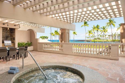 a hot tub in a room with a view of the ocean at Hilton Waikoloa Village in Waikoloa