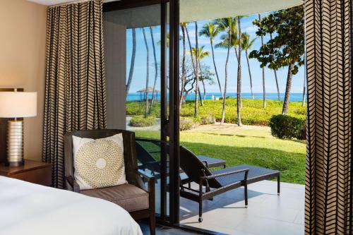 a bedroom with a bed and a view of the ocean at Hilton Waikoloa Village in Waikoloa