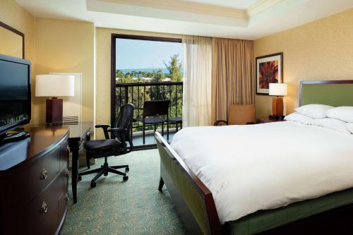 a hotel room with a bed and a large window at Hilton Waikoloa Village in Waikoloa