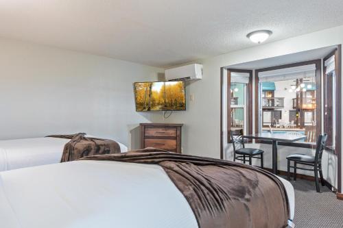 a hotel room with two beds and a balcony at Cragun's Resort on Gull Lake in Brainerd