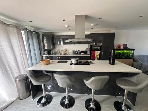 eine Küche mit einer Insel mit Barhockern in der Unterkunft Stretford Townhouse Bedroom in Manchester
