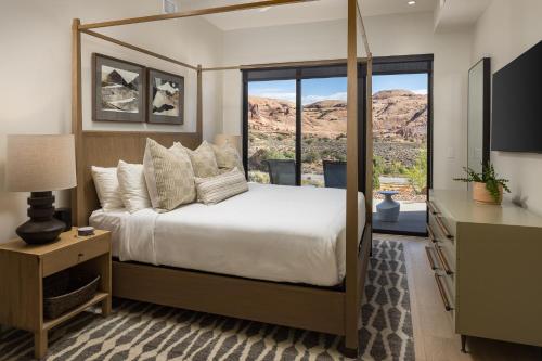 a bedroom with a bed and a large window at LIONSBACK RESORT in Moab