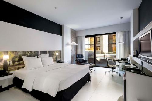 a hotel room with a large bed and a desk at Hilton Madrid Airport in Madrid