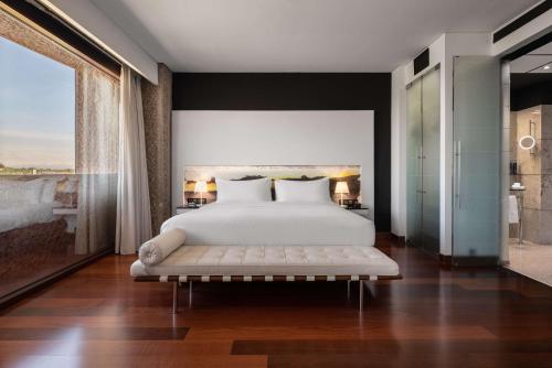 a bedroom with a white bed and a large window at Hilton Madrid Airport in Madrid