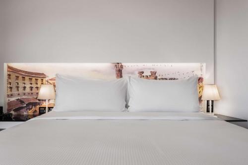 a white bed with two pillows and two lamps at Hilton Madrid Airport in Madrid