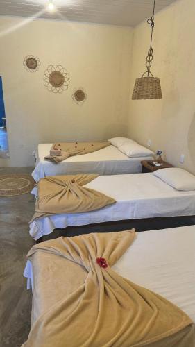 a group of three beds in a room at Milagres Retrô- Studio in São Miguel dos Milagres