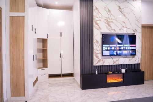 a living room with a fireplace and a tv on a wall at ABOT Luxury Homes in Lekki