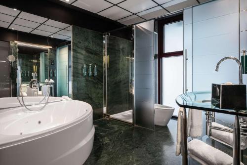 a bathroom with a tub and a toilet and a sink at Hilton Madrid Airport in Madrid