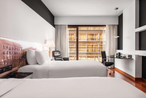 a hotel room with two beds and a window at Hilton Madrid Airport in Madrid