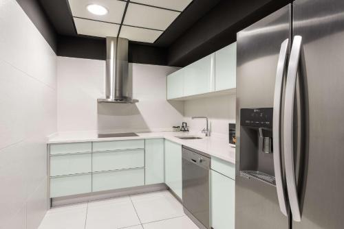 a kitchen with white cabinets and a stainless steel refrigerator at Hilton Madrid Airport in Madrid