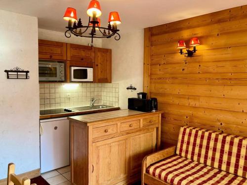 une cuisine avec un comptoir et une chaise dans l'établissement Résidence Meijotel - Studio résidence Meijotel MAE-9301, à Vénosc