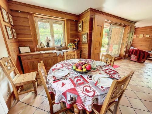 une salle à manger avec une table avec un bol de fruits dessus dans l'établissement Chalet Les Elfes - Alpine chalet au village, 100m de télécabine MAE-7361, à Les Allues