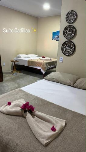 a hotel room with two beds with flowers on them at Milagres Retrô- Studio in São Miguel dos Milagres