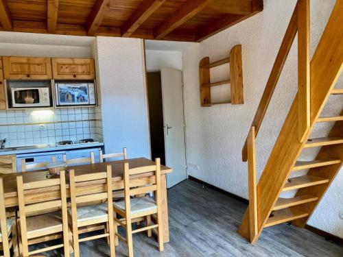 une cuisine et une salle à manger avec une table et un escalier dans l'établissement Résidence Meijotel - Appartement résidence Meijotel MAE-9761, à Vénosc