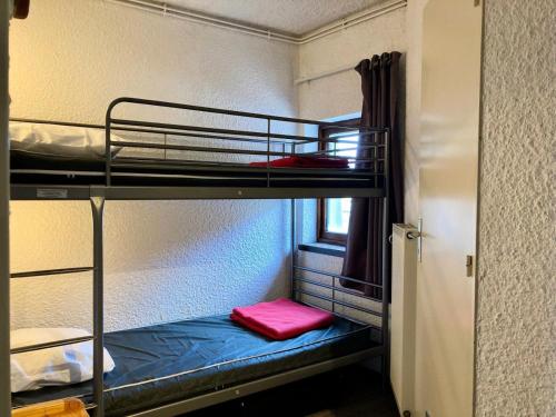 Cette chambre comprend 2 lits superposés avec un oreiller rouge. dans l'établissement Résidence Meijotel - Appartement résidence Meijotel MAE-9761, à Vénosc