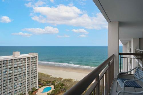 a balcony with a view of the beach at Embassy Suites by Hilton Myrtle Beach Oceanfront Resort in Myrtle Beach