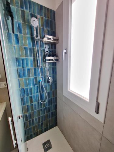 a bathroom with a shower with a blue tiled wall at EndlessSummer in Focene