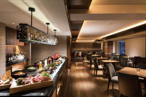 a dining room with tables and chairs and a buffet at Hilton Nagoya Hotel in Nagoya