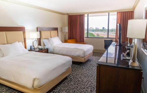 a hotel room with two beds and a window at Hilton Palm Beach PBI in West Palm Beach