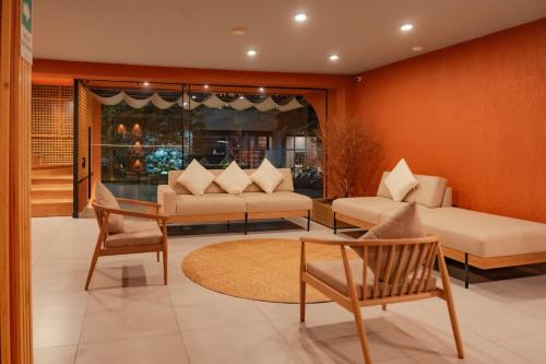 a living room with two couches and a table and chairs at Leviu by Bernalo Hotels in Medellín