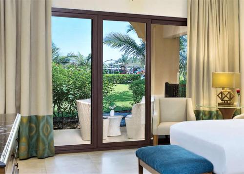 a hotel room with a bed and a sliding glass door at DoubleTree by Hilton Resort & Spa Marjan Island in Ras al Khaimah
