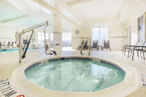 a jacuzzi tub in a large room with chairs at Hilton Garden Inn Roanoke Rapids in Roanoke Rapids