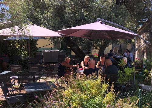 a group of people sitting at a table under an umbrella at Appartamento vacanze "Borgo Cinque Terre" Volastra Manarola in Volastra