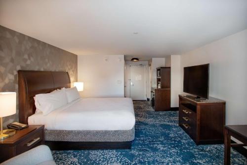 a hotel room with a bed and a flat screen tv at Hilton Garden Inn Bethesda Downtown in Bethesda