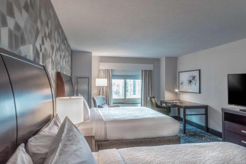a hotel room with two beds and a television at Hilton Garden Inn Bethesda Downtown in Bethesda