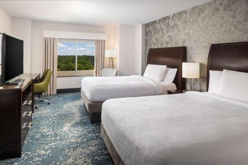 a hotel room with two beds and a television at Hilton Garden Inn Bethesda Downtown in Bethesda
