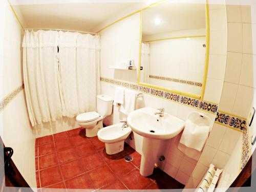 a bathroom with two toilets and a sink and a mirror at El Mirador Del Parque in Gúa