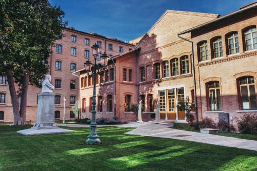 a building with a statue in the grass in front of it at Hilton Molino Stucky Venice in Venice